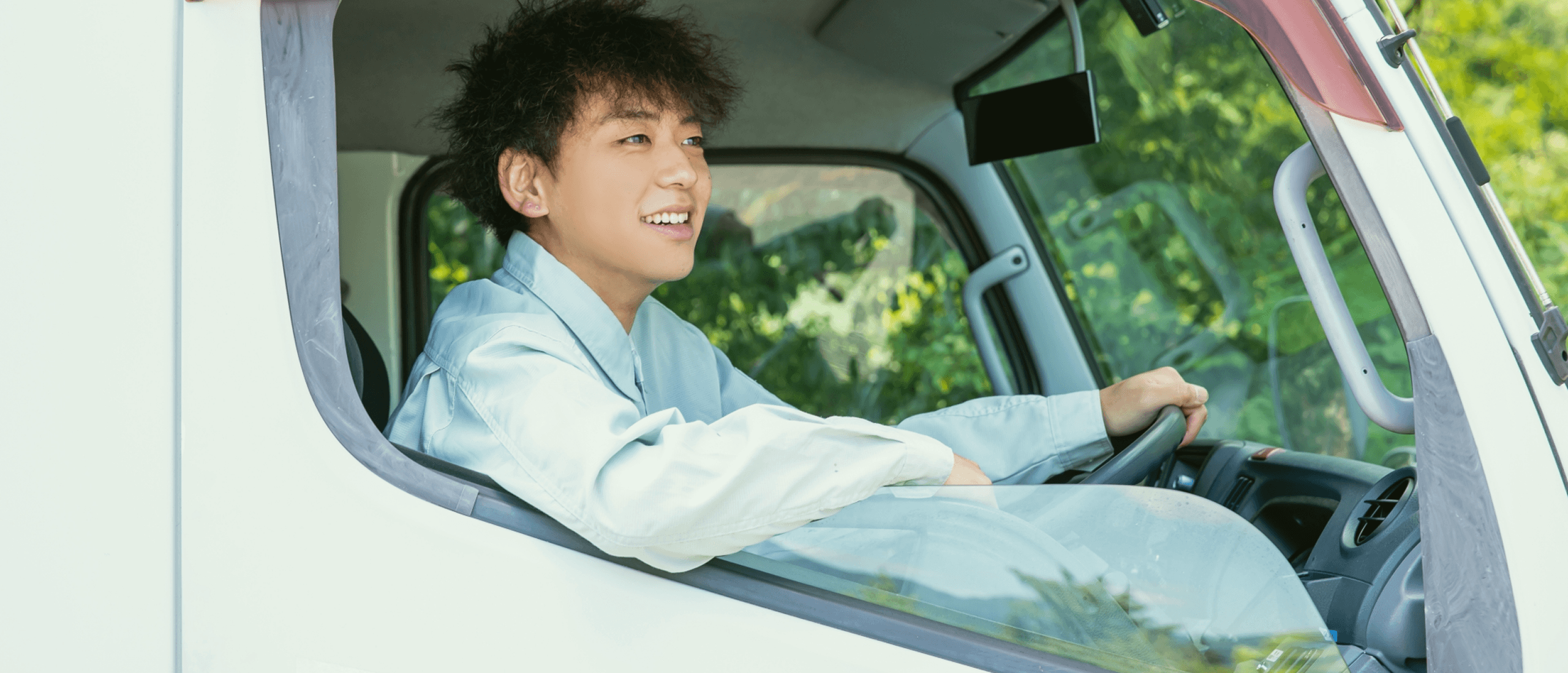 トラックの運転席に座るスタッフ